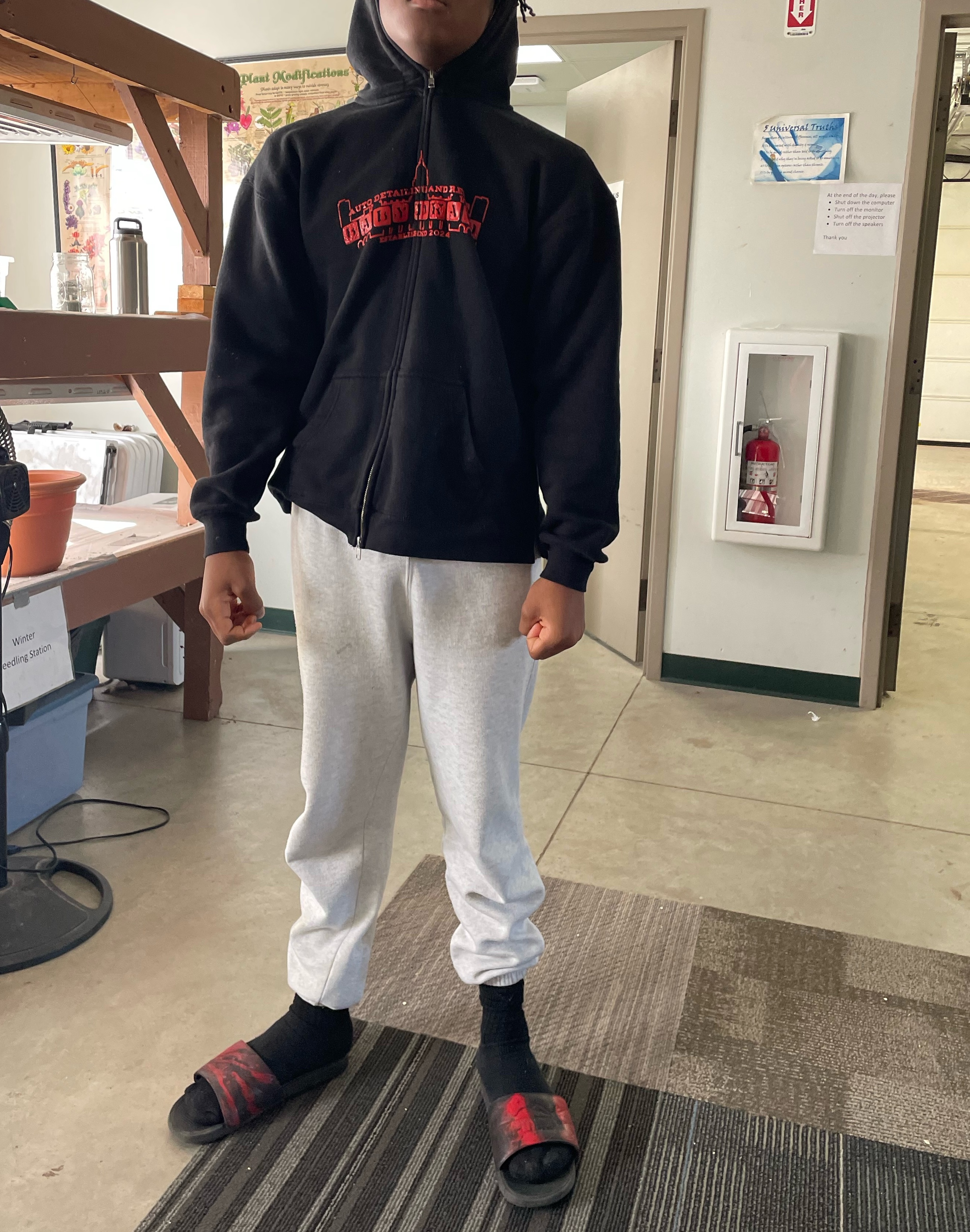 Student posing with their new branded sweatshirt and hydro-dipped slides