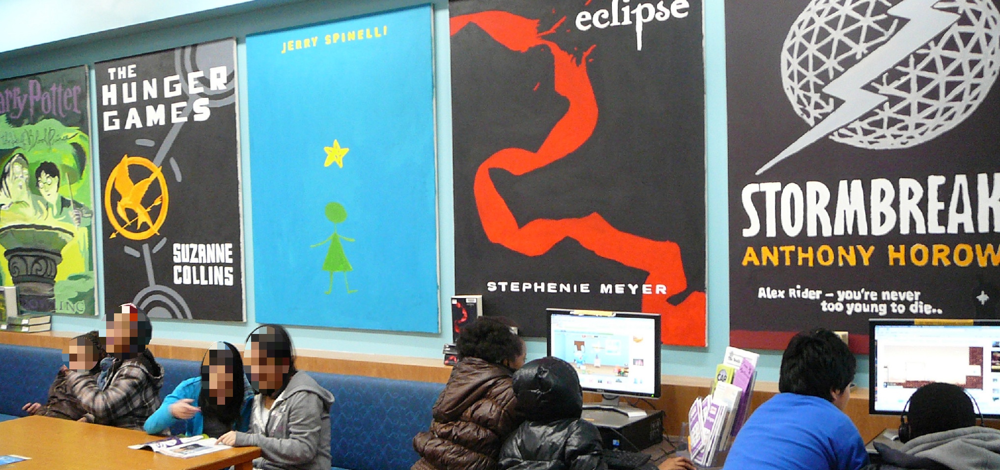 Picture of 5 different book covers painted on 5ftx4ft art boards by teens in south Madison.
