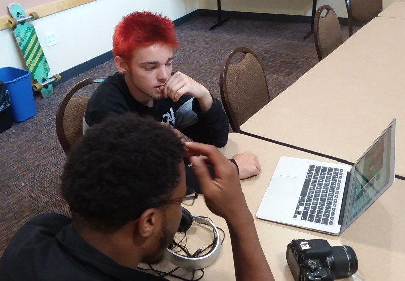 Picture of PLA intern, Eli Blakely, working on beat production with another student.