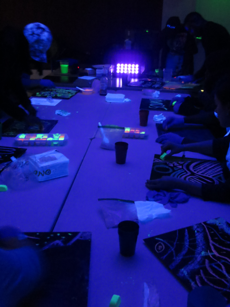picture of group drawing during Carlos Gacharna's black light chalk workshop