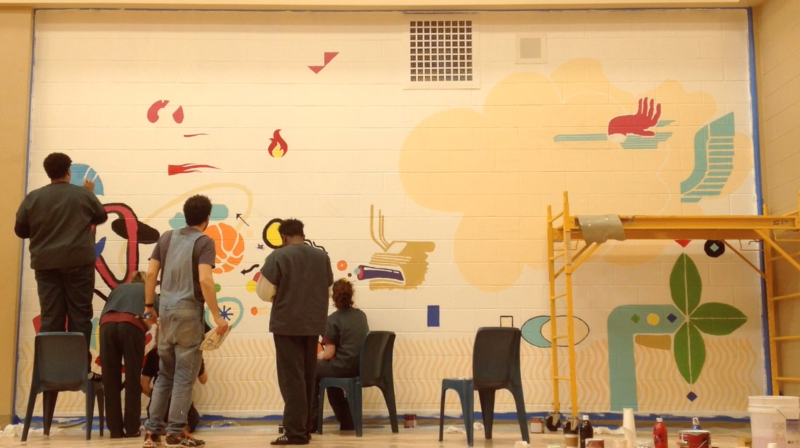 picture of students and artist painting "The Well of Being" mural.