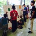 Teens are working with a Bubbler artist to paint a mural in the library.